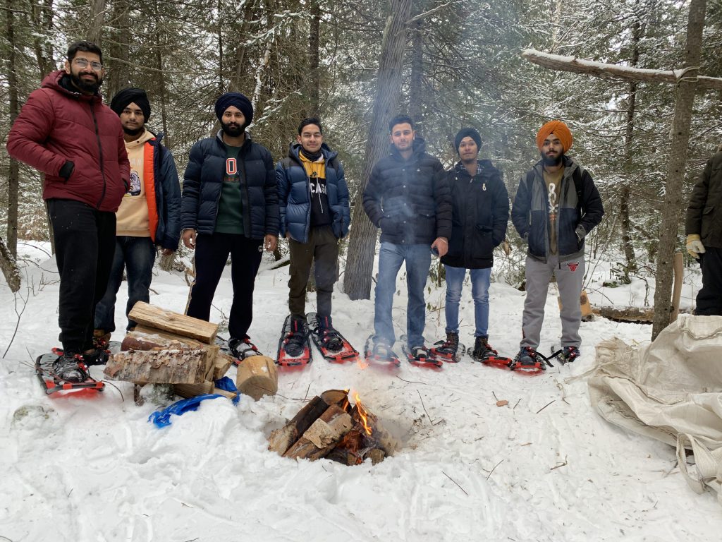 Northern College enjoying a fire outside after snowshoeing