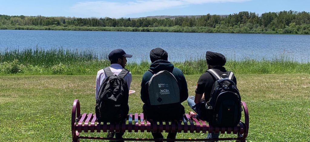 Northern College International students sitting outside having a break by the water