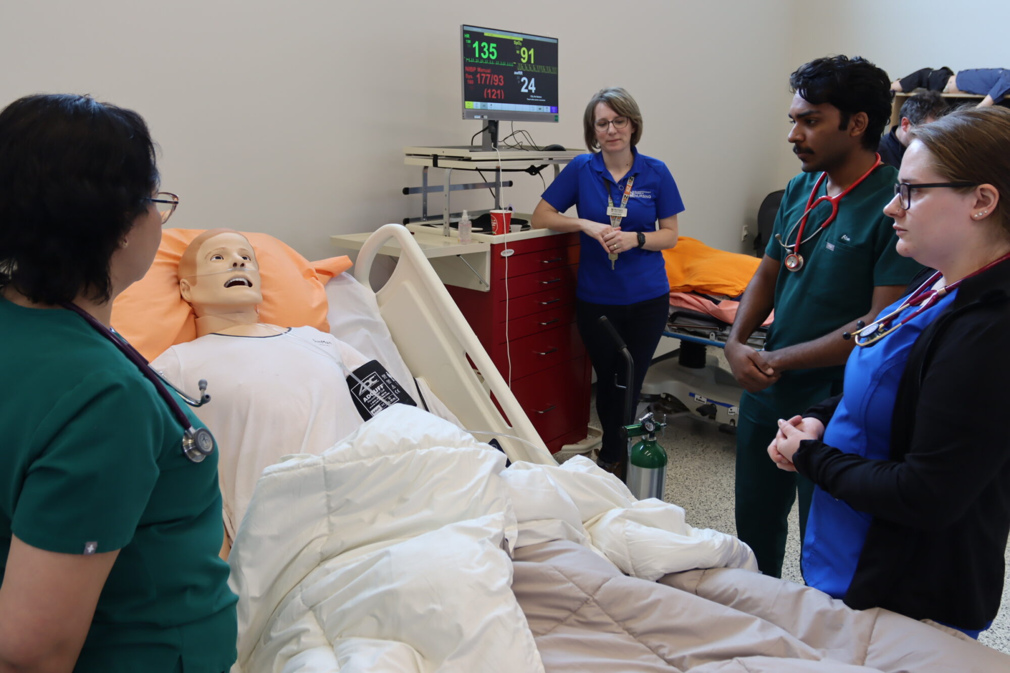 Nursing mock scenario at Northern College - Students and an instructor around a bed with a fake patient