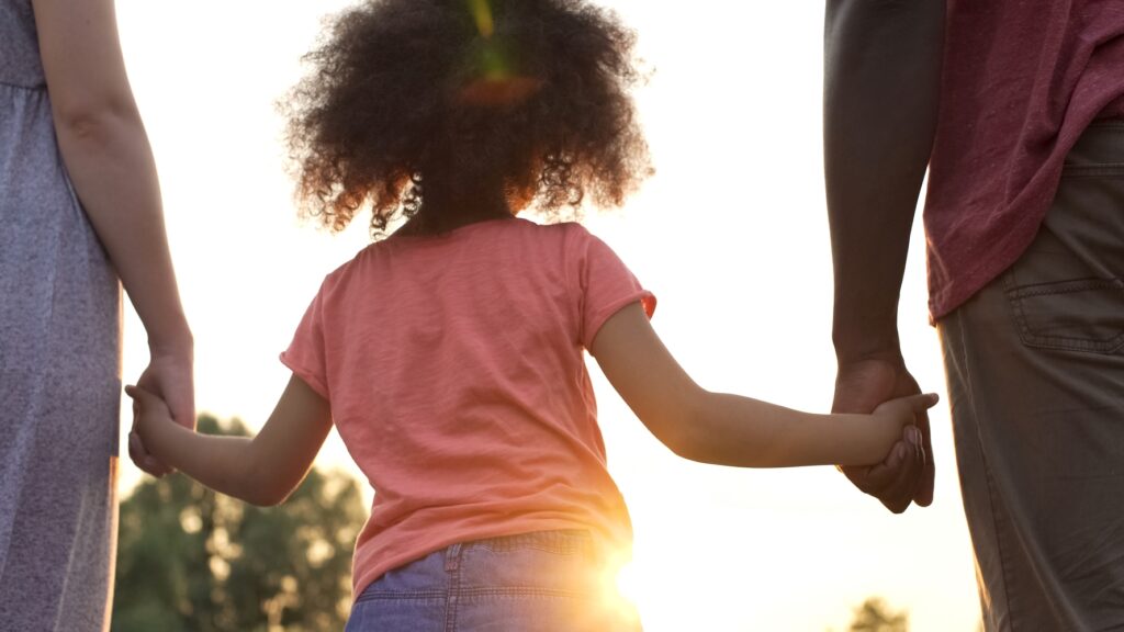 child holding adults' hards