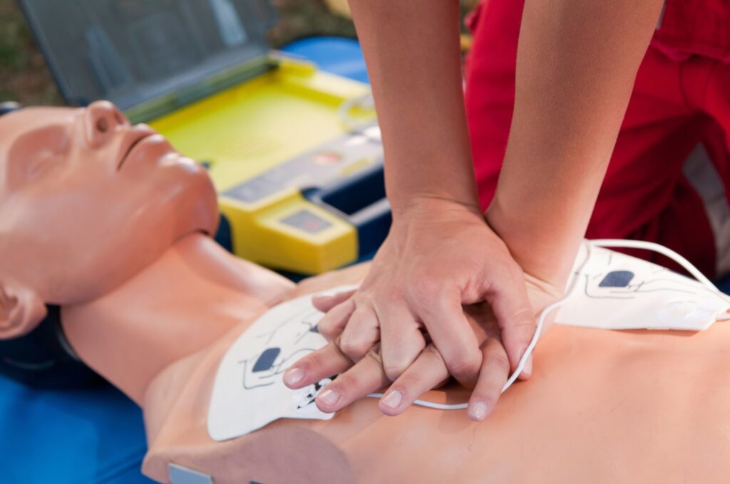 person performing cpr training on manequin