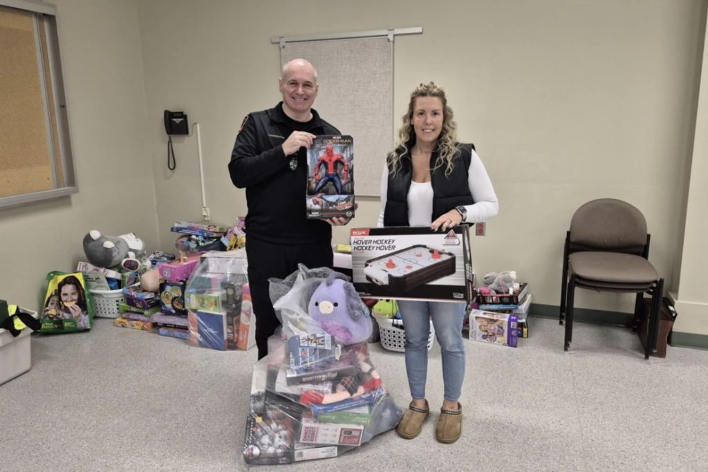 A man and a lady presenting gifts at a Toy Drive