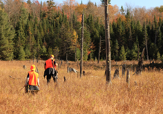 Firearm course at Northern College - Two people in orange hunting in the forest