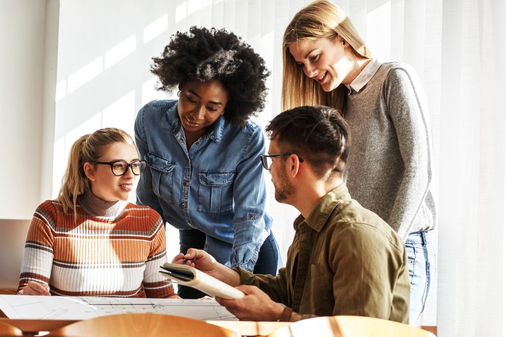 Group of students, 3 woman and one man, doing homework together