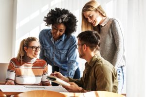 Group of students, 3 woman and one man, doing homework together