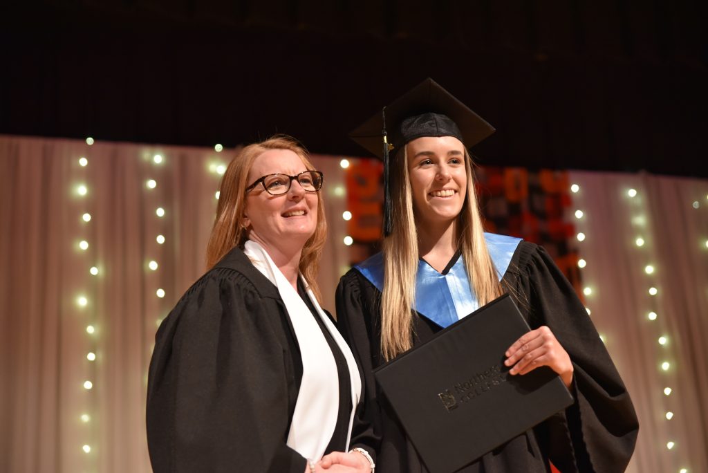 Teacher shaking hand with graduate from Northern College Haileybury Campus