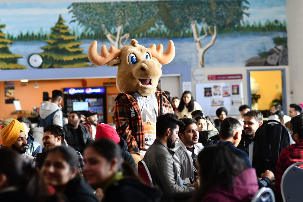 Group of Northern College students with moose mascot in cafeteria
